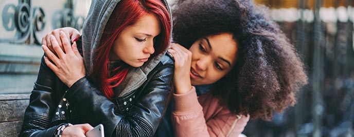 One young lady comforting another