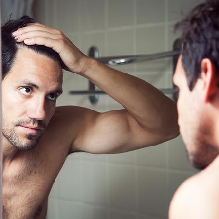 Man looking at balding spot