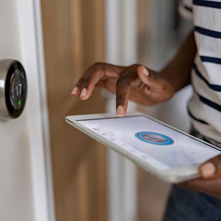 Lady controlling thermostat via a tablet