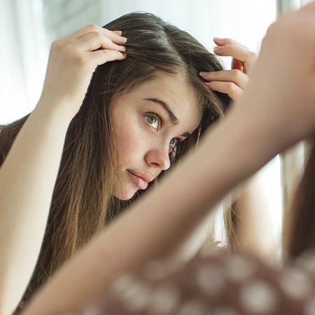 Lady looking at thinning hair line